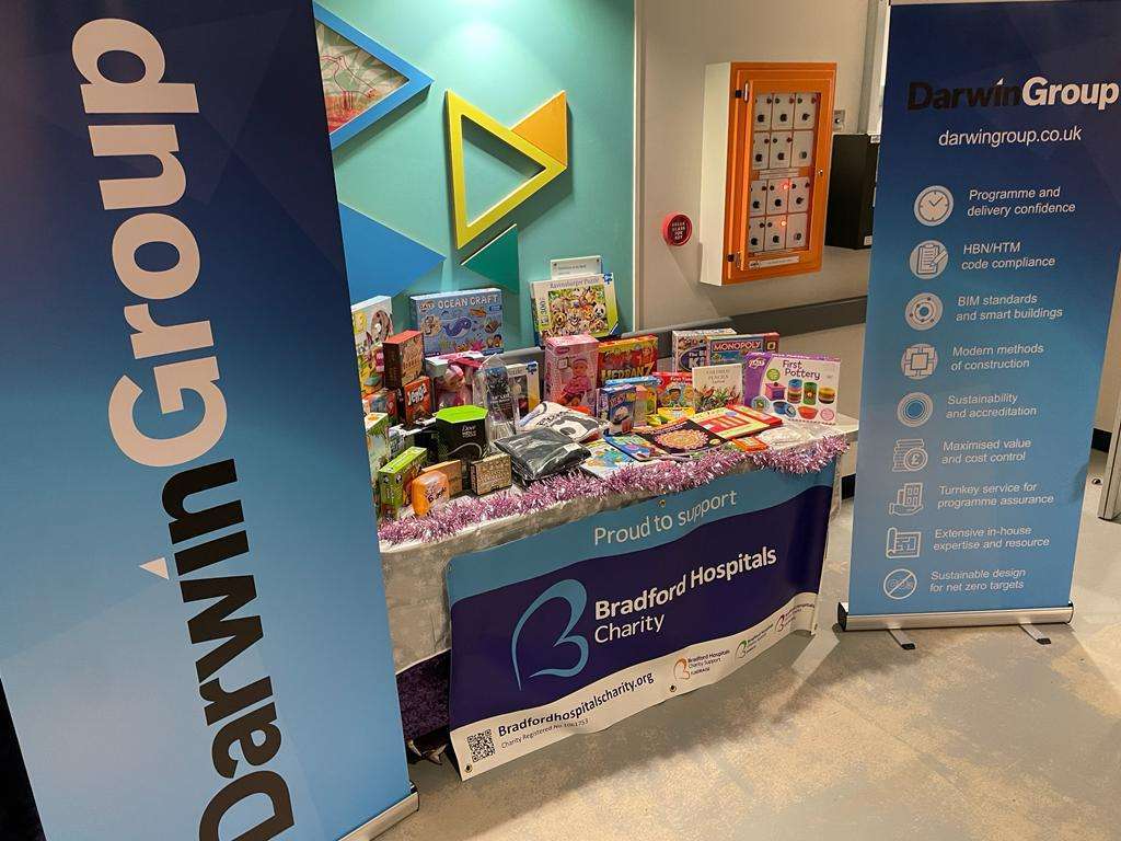 A table full of toys and games, with Darwin Group banners to either side.