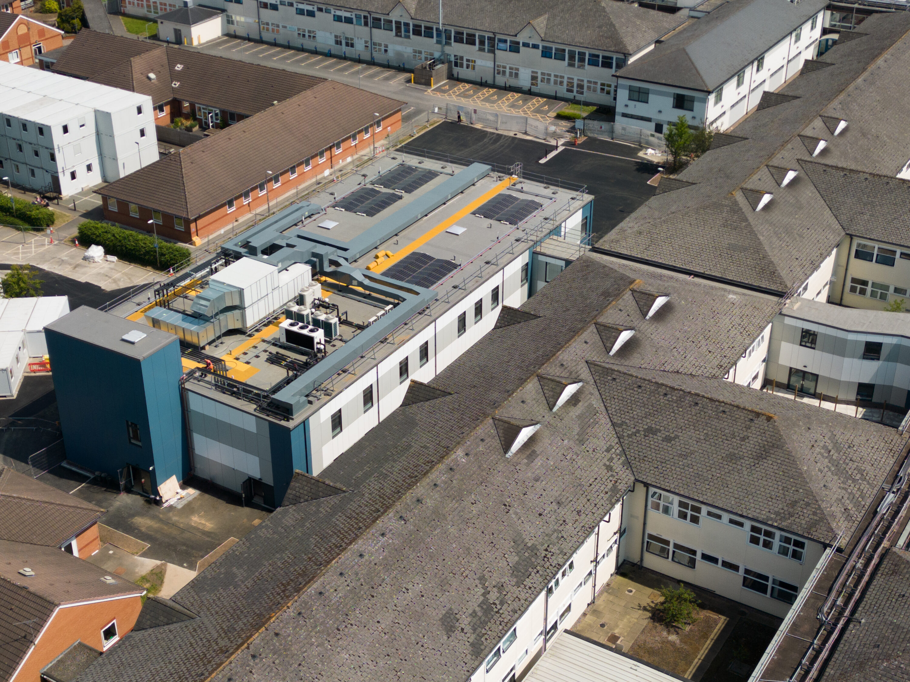 bird's eye view of the ward building amongst the older hospital buildings. You can see the plant and solar panel installation on the roof.