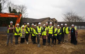 Group of people in high-vis and safety helmets at a ground breaking ceremony at Calderdale