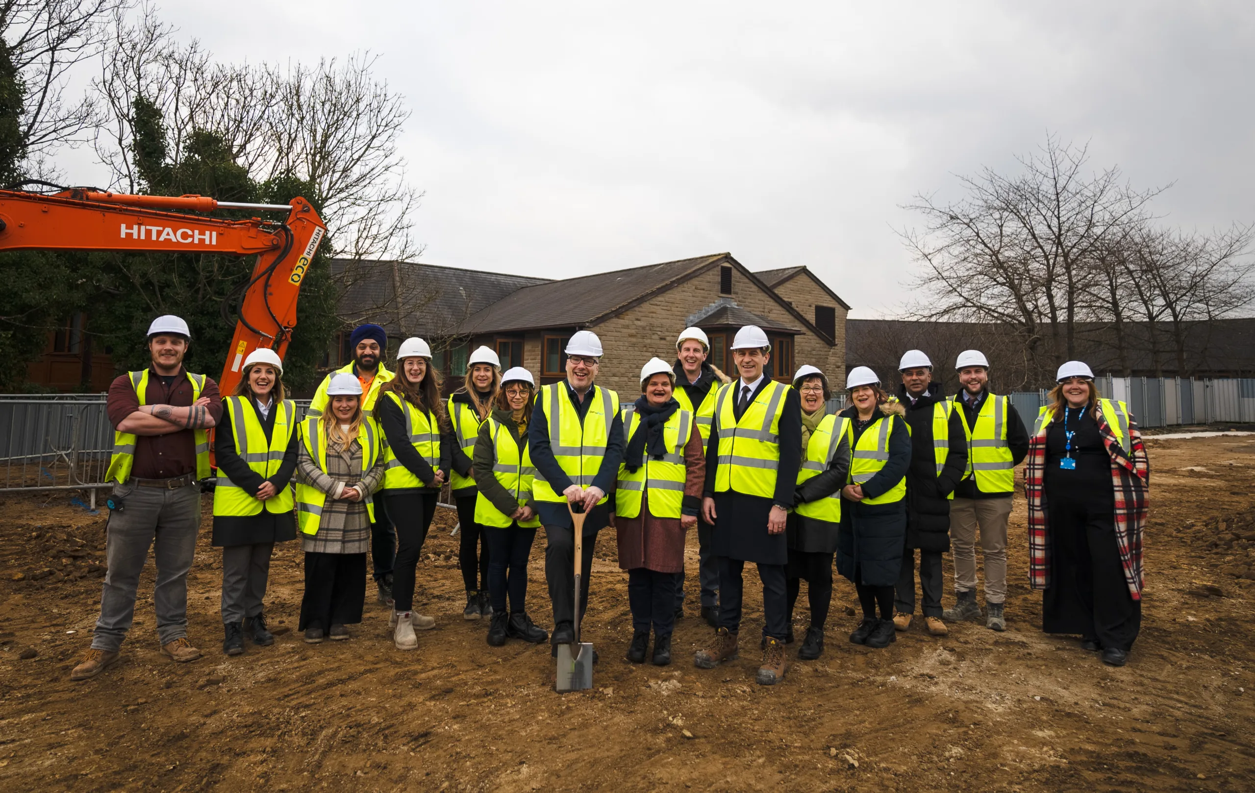 Group of people in high-vis and safety helmets at a ground breaking ceremony at Calderdale